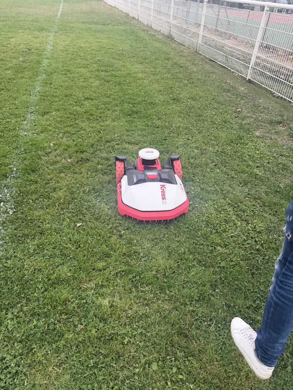 Robot Kress tondant le long de la clôture d’un terrain de rugby