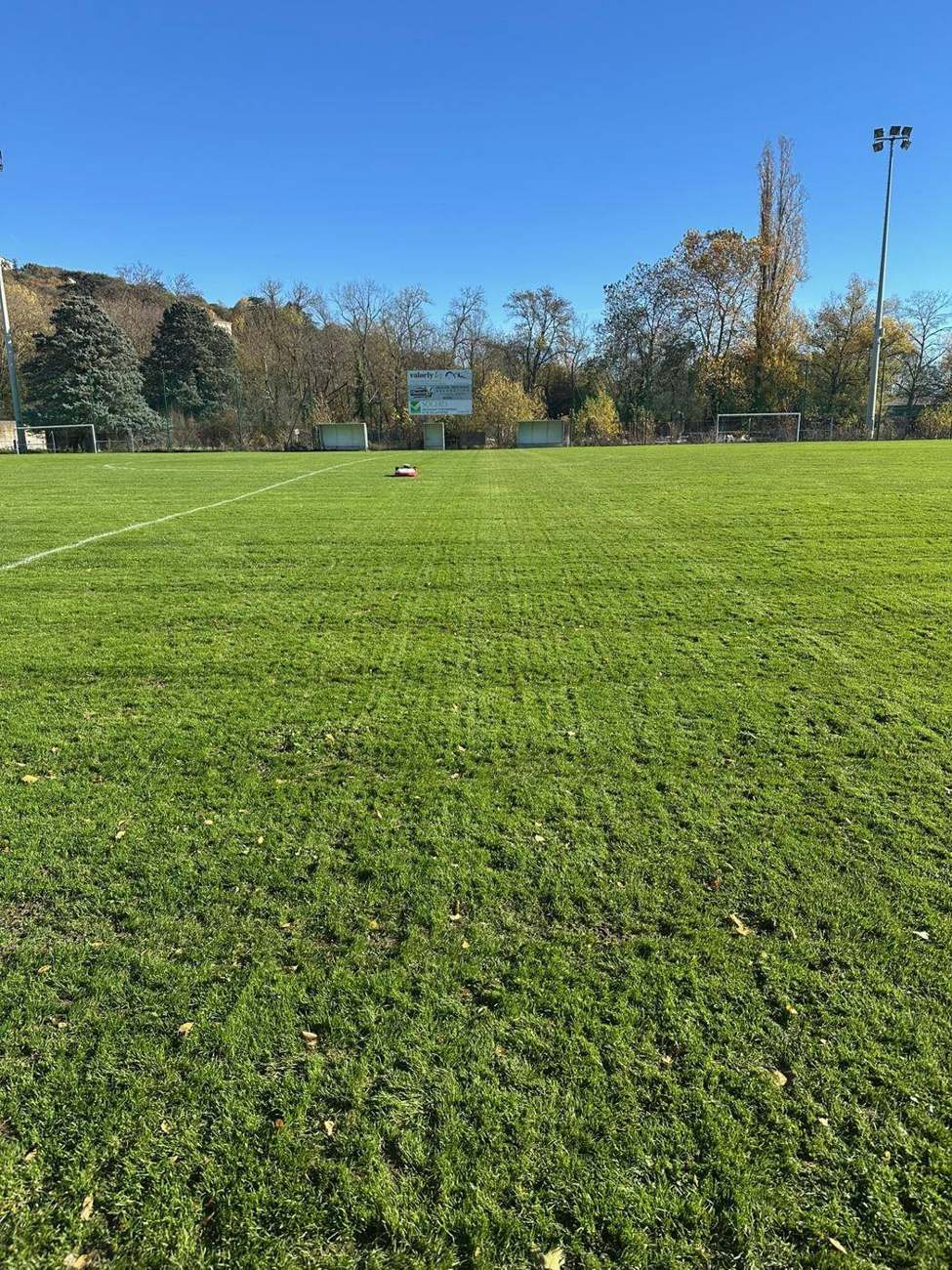Robot tondeuse installé par la Clinique de la Tondeuse sur un terrain de football de l’Est lyonnais