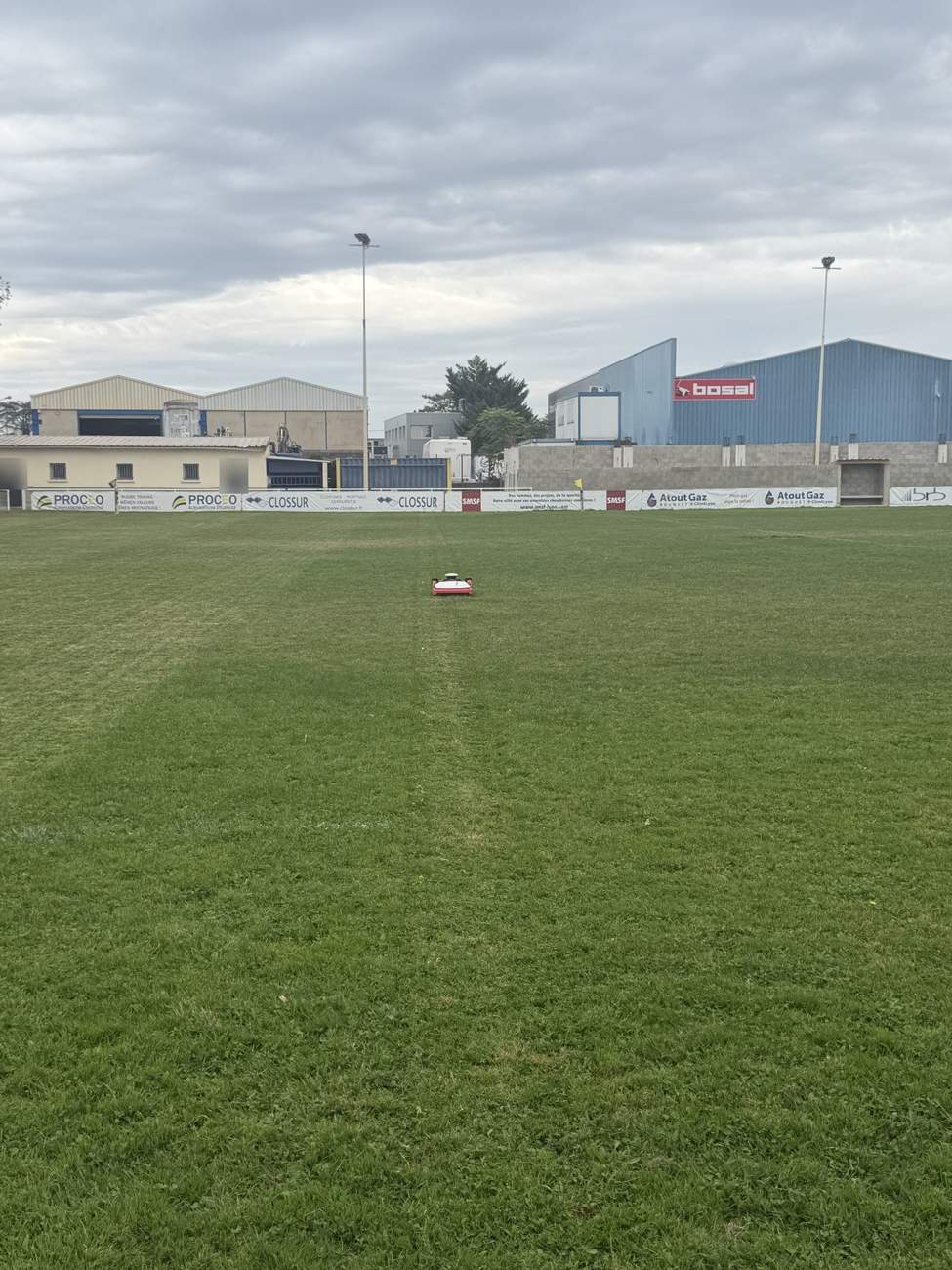 Robot tondeuse au milieu d’un terrain de rugby de l’Est lyonnais