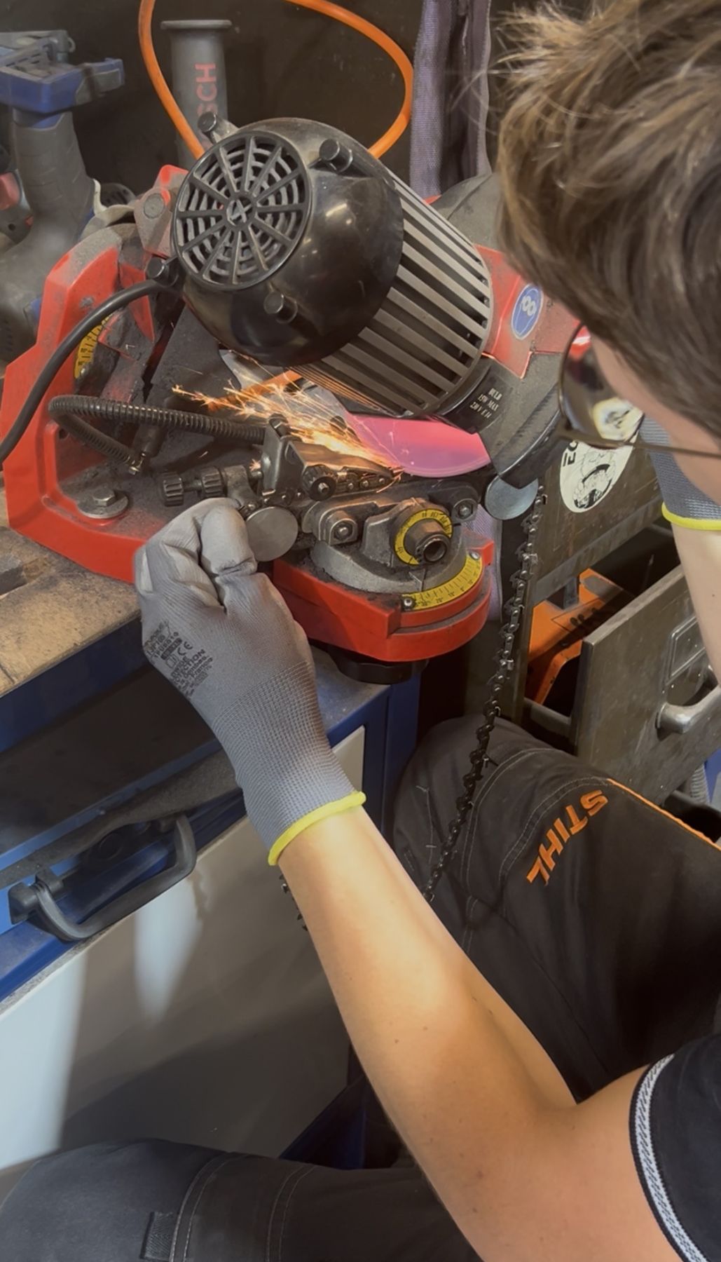 Technicien affûtant une chaîne de tronçonneuse à l’atelier