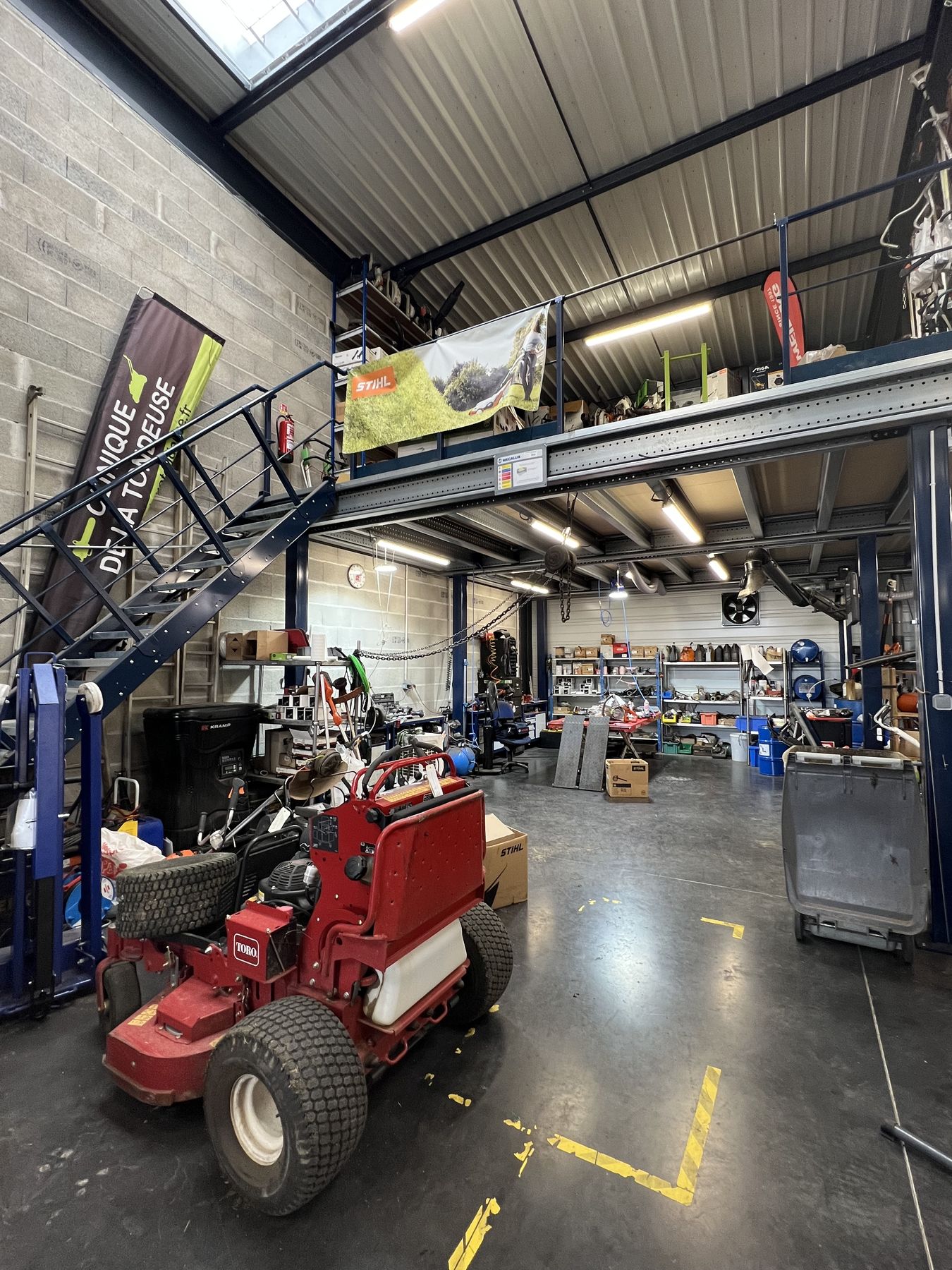 Atelier de réparation de la Clinique de la Tondeuse avec mezzanine de pièces détachées